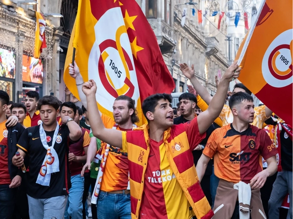 Begeisterte Fußballfans in gelb-roten Vereinstrikots ziehen lautstark mit Fahnen durch die Straßen Istanbuls. Das perfekte Ziel für ein intensives Fan-Wochenende.